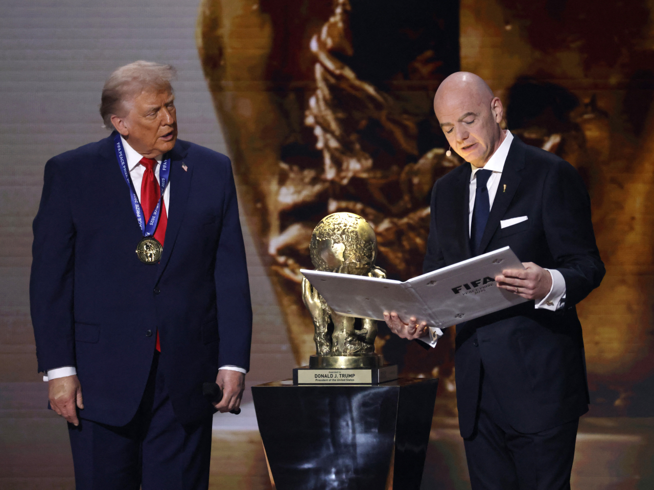 Gianni Infantino pays tribute to Donald Trump after presenting him with the gold medal and trophy during the Fifa World Cup 2026 final draw in Washington. Photo: Reuters