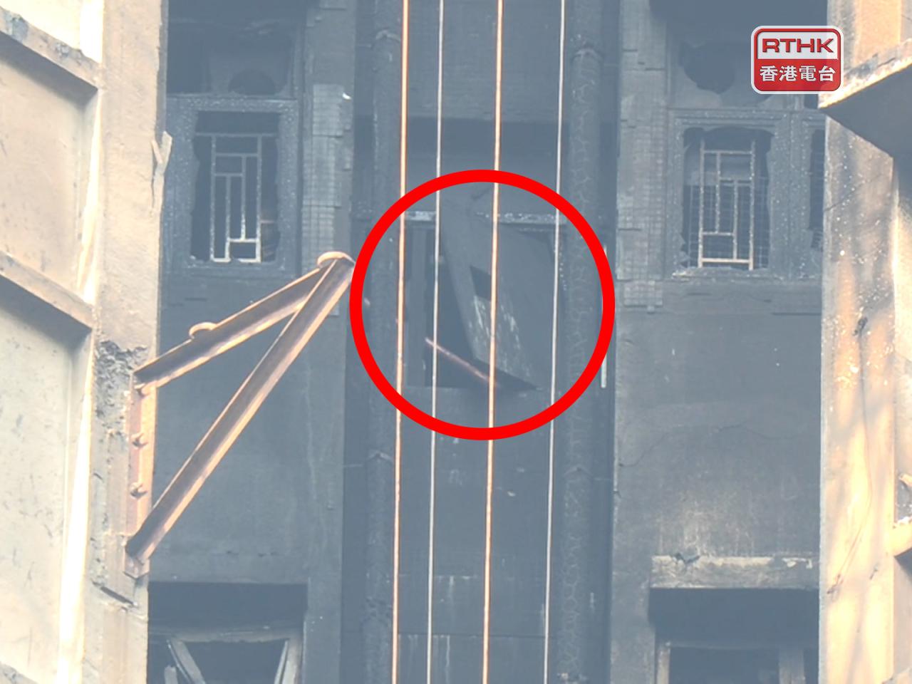 宏新閣高層後樓梯位置有木板懸掛在窗外。（鍾家銘攝）