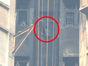 宏新閣高層後樓梯位置有木板懸掛在窗外搖搖欲墜。（鍾家銘攝）