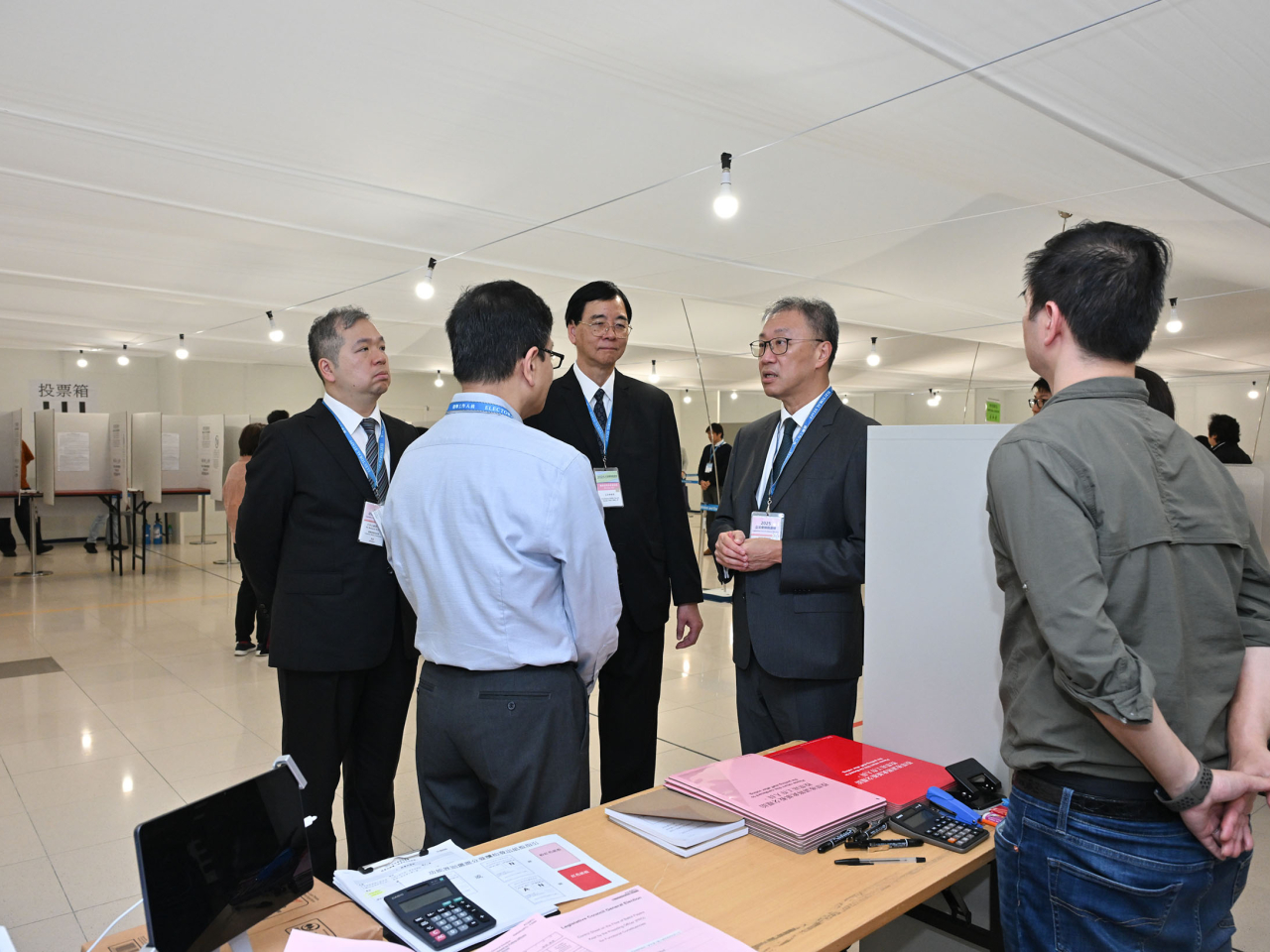 陸啟康（右）早上聯同石丹理（中）及文本立（左）巡視設邊境投票站，了解票站運作情況。（政府新聞處）