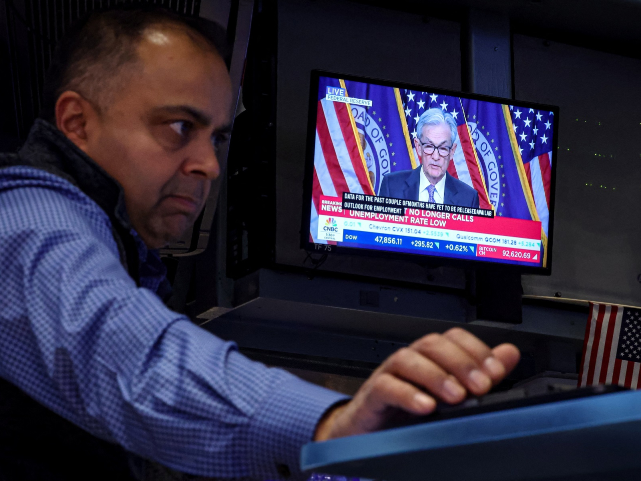 A trader works on the floor of the New York Stock Exchange, as a screen broadcasts a news conference by US Federal Reserve Chair Jerome Powell. Photo: Reuters