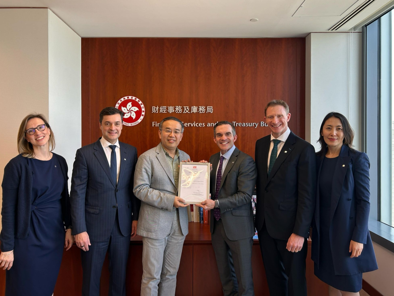 許正宇（左3）與宏利代表會面，宏利人壽保險（國際）是首家遷冊來港的保險公司。（財庫局圖片）