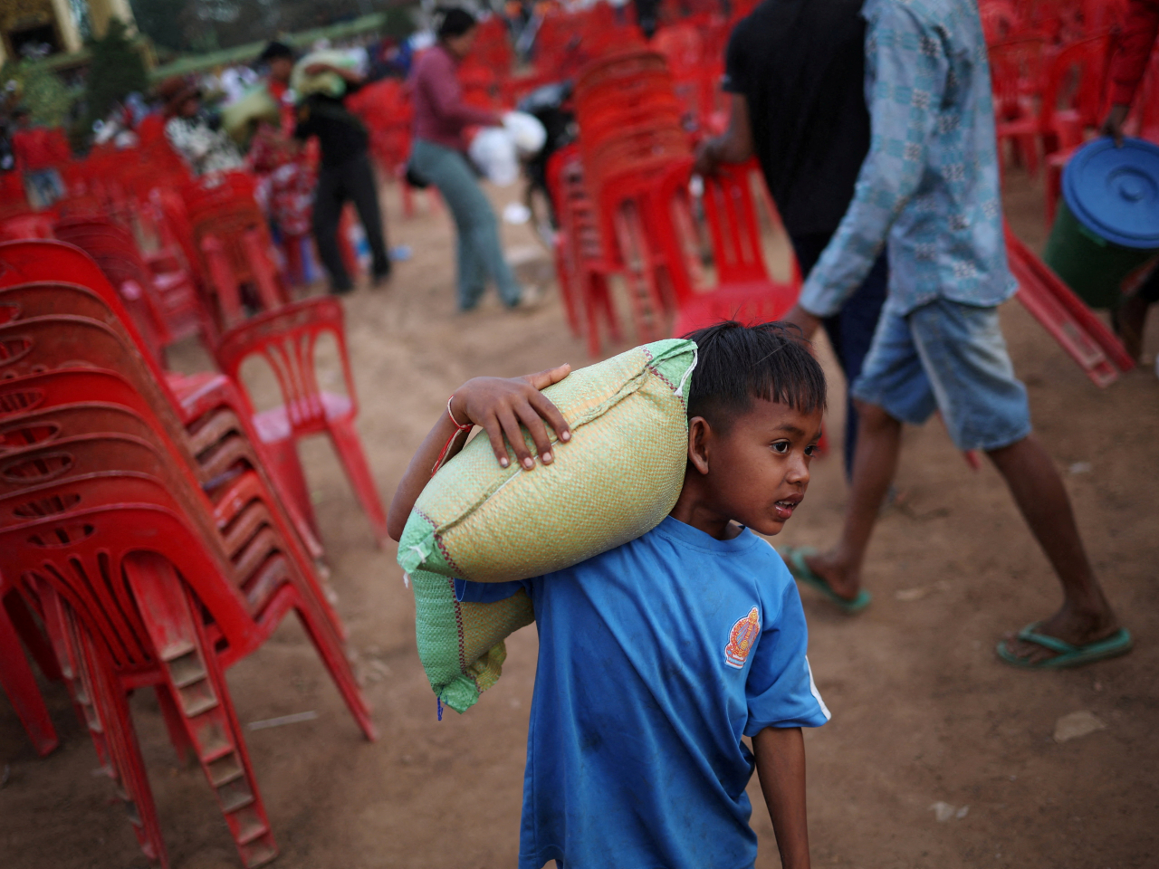 在柬埔寨奧多棉吉省，一名男童在難民營附近接收援助物資。（路透社）