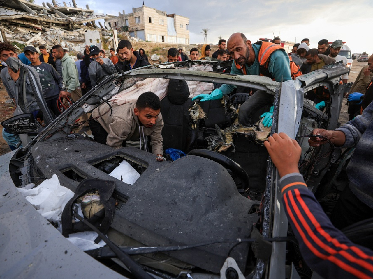 Palestinians inspect what is left of the car after the Israeli strike in Gaza City. Photo: Reuters