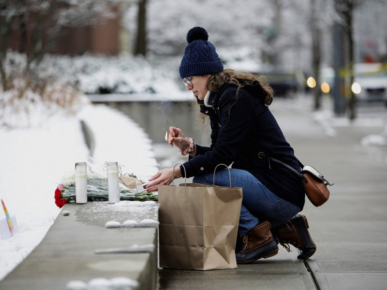 A woman lights candles in front of the Barus & Holley engineering building at Brown University. Photo: Reuters