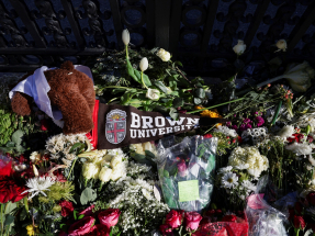 Flowers and a stuffed bear rest in front of the Van Wickle Gates as the manhunt continues for the gunman, following a shooting at Brown University in Providence, Rhode Island. Photo: Reuters