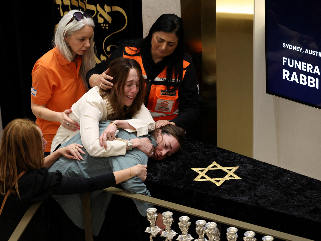 Family members of Rabbi Eli Schlanger, who was killed during the shooting at Bondi Beach on Sunday, react as they lean over his casket during his funeral. Photo: Reuters