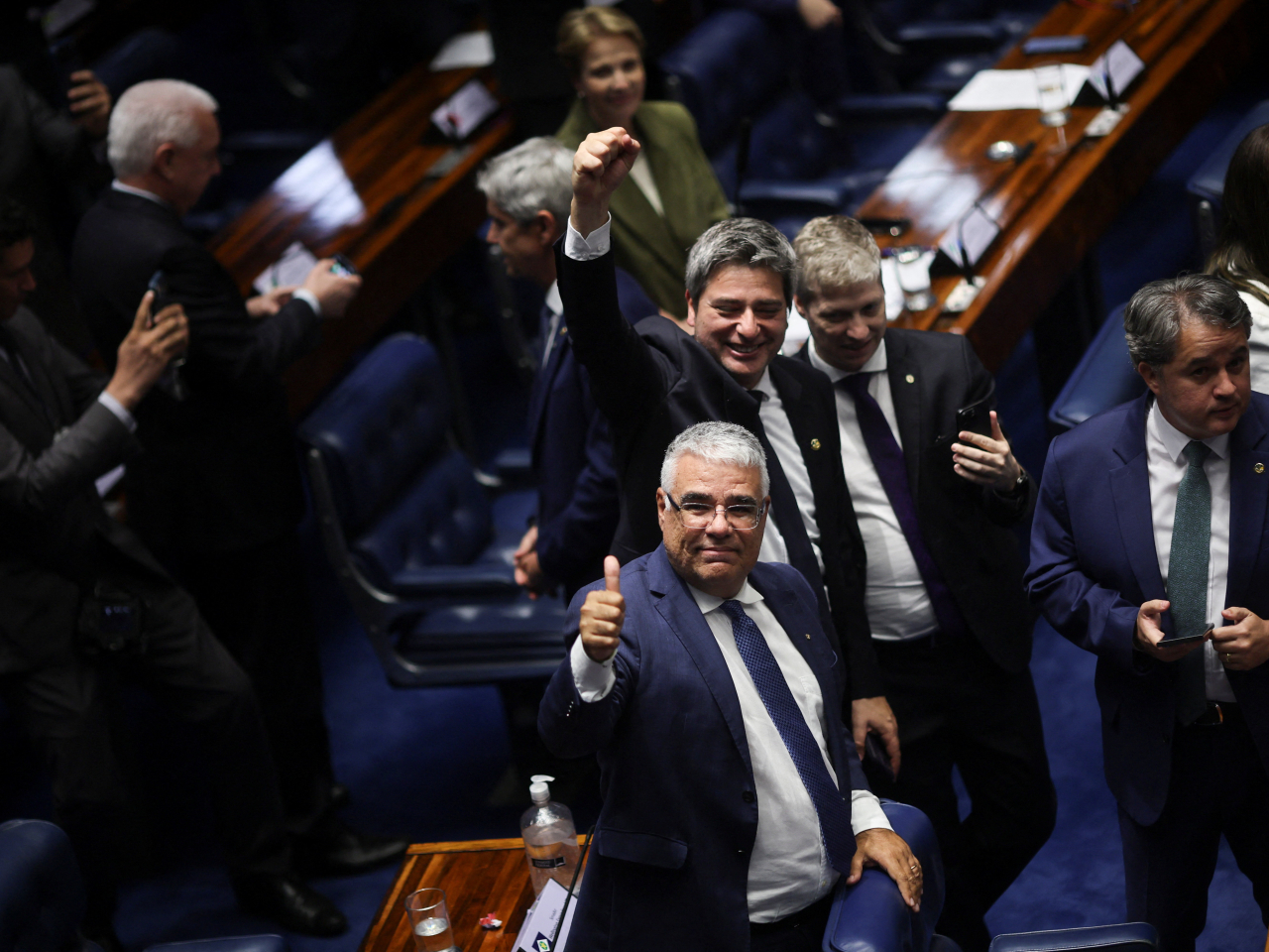 Senators in good cheer following voting that slashed the prison sentence of Jair Bolsonaro over a coup bid that included alleged assassination attempts. Photo: Reuters