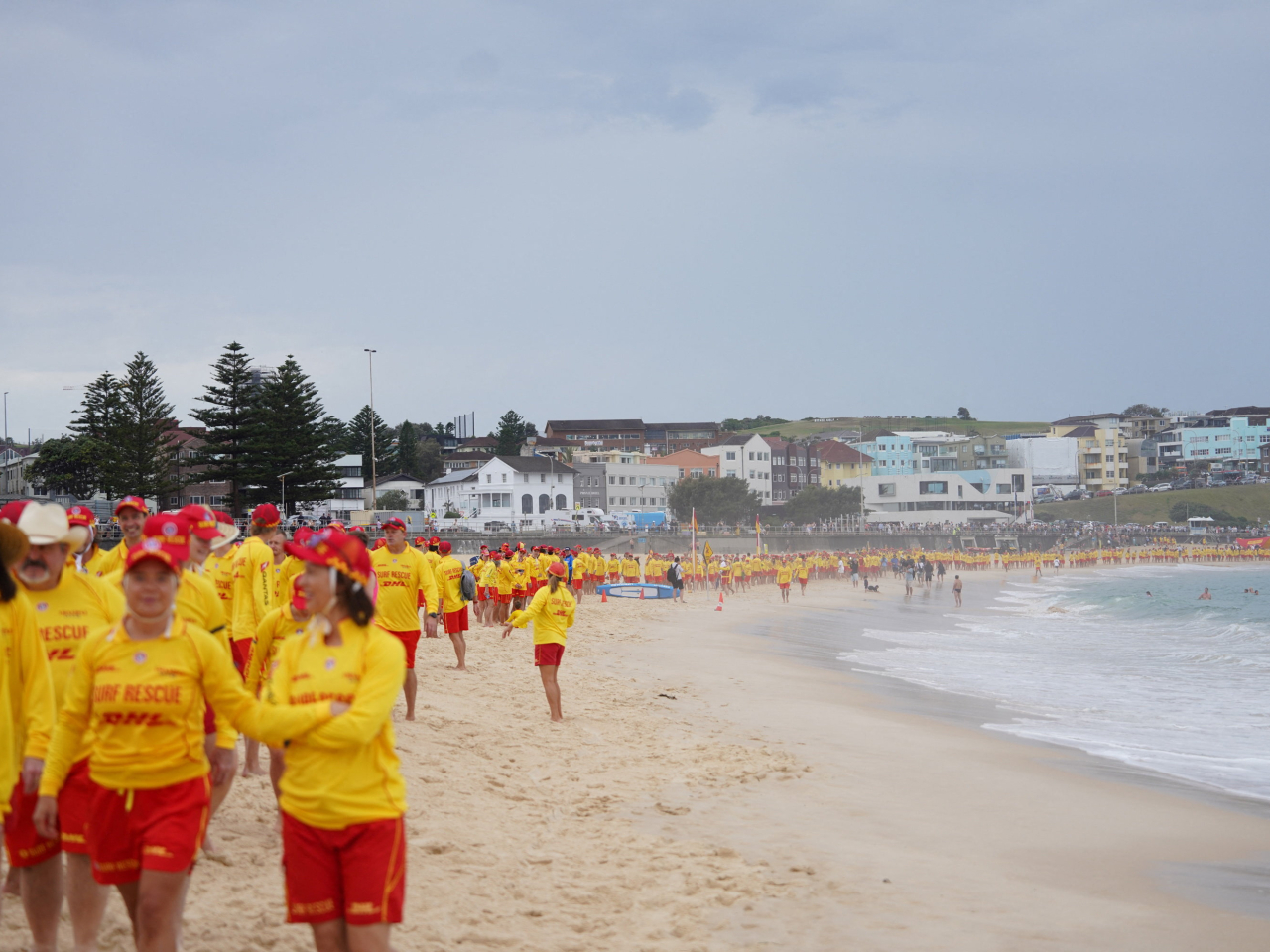 Surf lifesavers form a line at Bondi Beach in respect to 'those who lost lives, those who risked lives, those who worked so hard to save lives'. Photo: Reuters