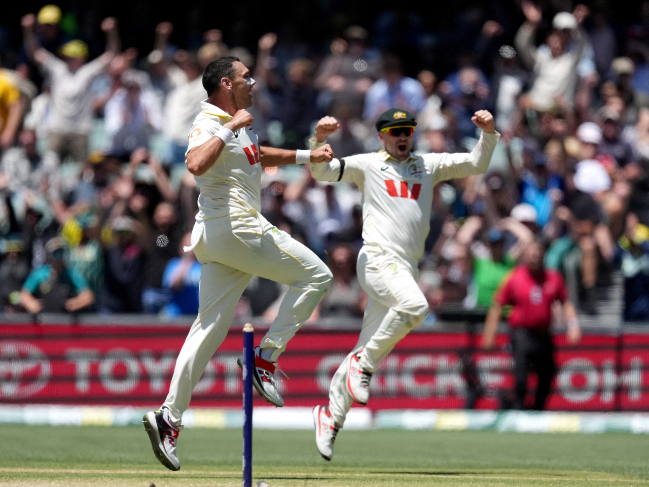 Australia's Scott Boland, left, celebrates taking the winning wicket. Photo: Reuters