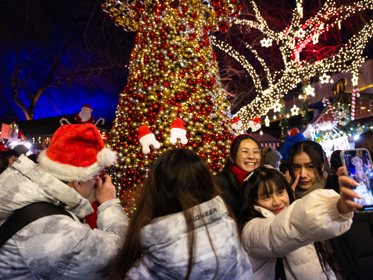 Visitors take a selfie as they stand next to an illuminated decoration in Beijing. Snowfall is in the forecast for the northern parts of the country. File photo: Reuters