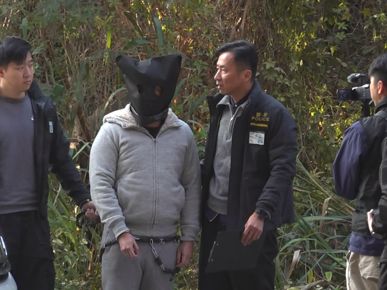 Officers took one of the suspects to the scene of the alleged attack for case reenactment. Photo: RTHK