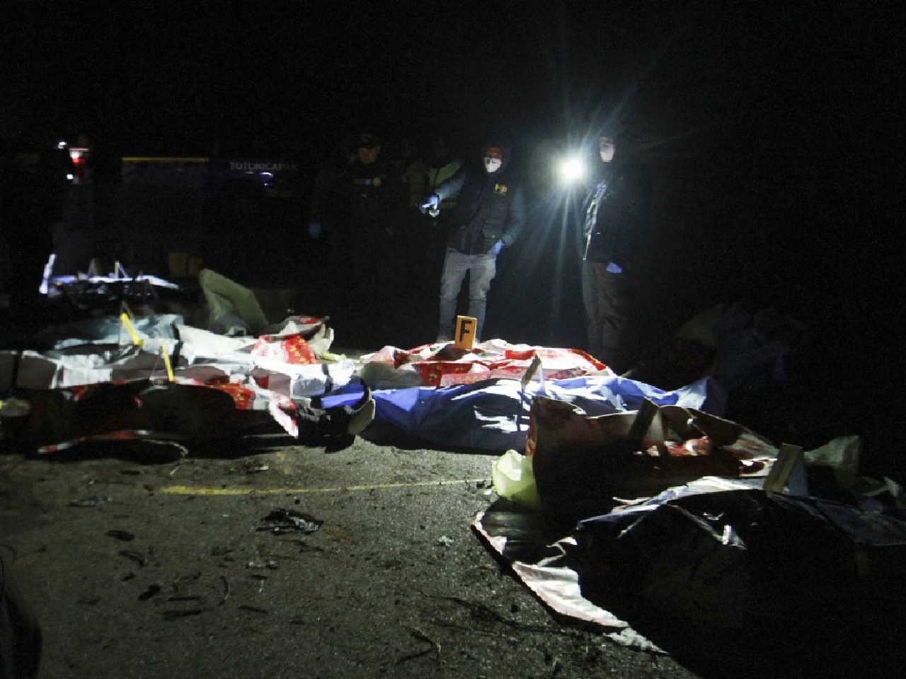 當局人員在現場調查巴士墮谷的原因。（法新社）