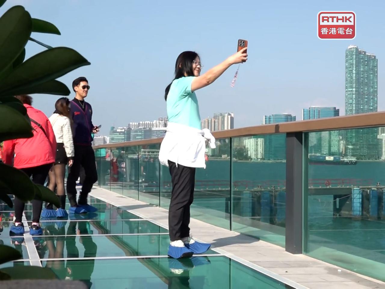 進入玻璃觀景台的人士要穿上由場地提供的鞋套，站在玻璃面可看到腳下的維港。（林紹鋒攝）