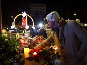 A man leaves a candle outside the "Le Constellation" bar following the deadly fire. Photo: Reuters