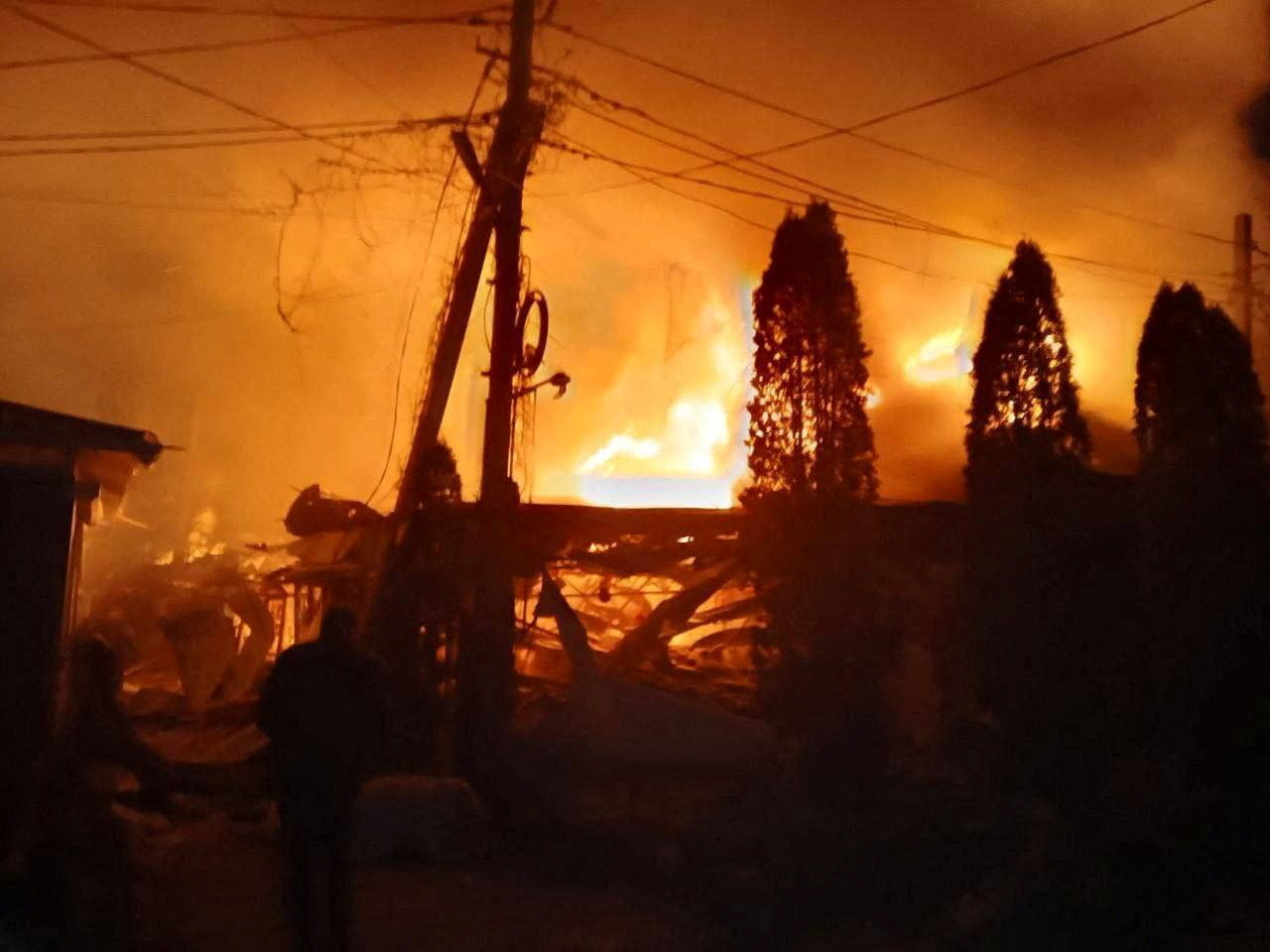 Flames and smoke rise from a fire following what Russian-installed authorities described as an overnight Ukrainian drone strike on a hotel and cafe in the village of Khorly, in the Kherson Region. Photo: handout via Reuters