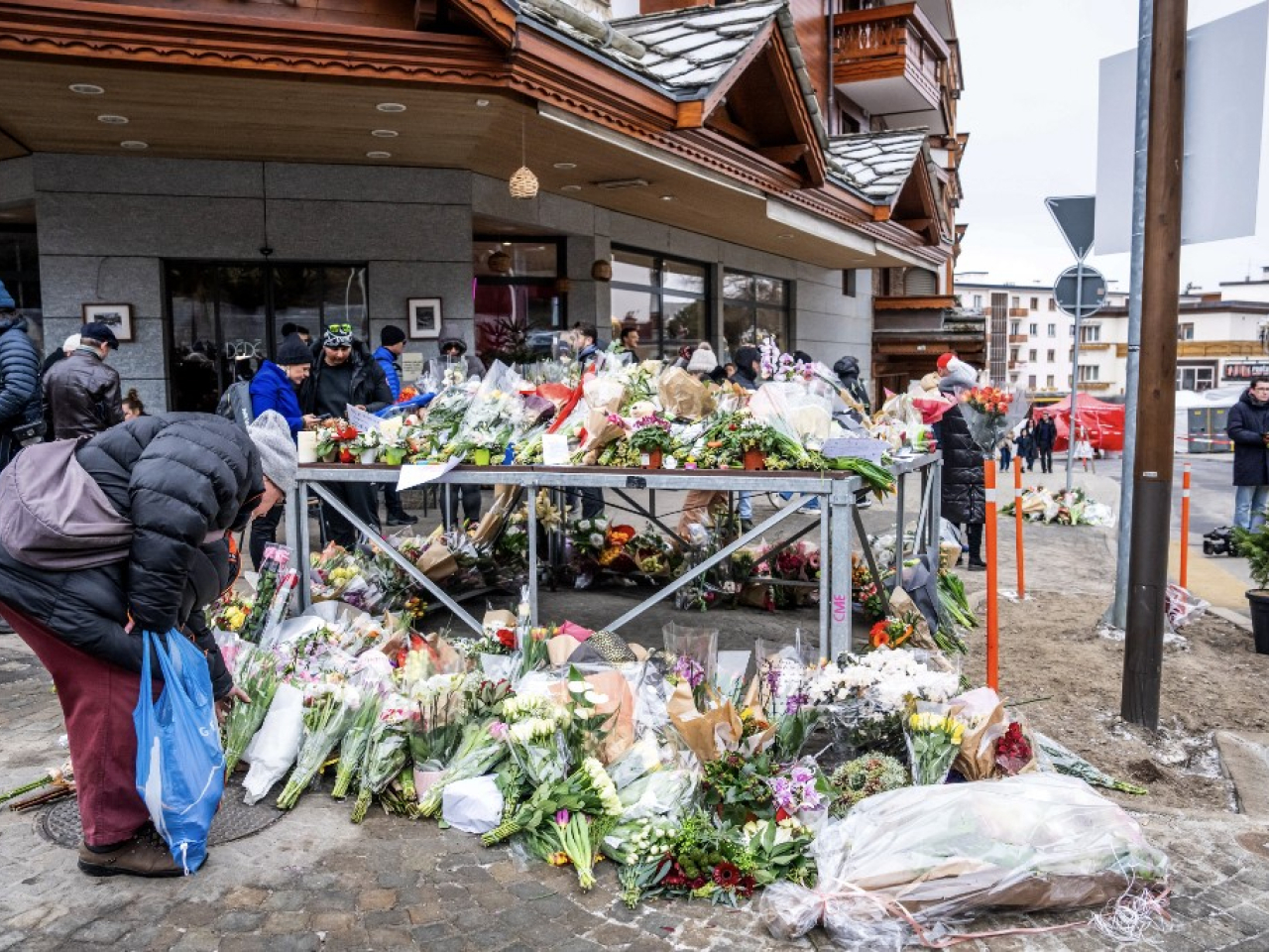Mourners lay flowers near the Le Constellation bar in Crans Montana. Photo: AFP