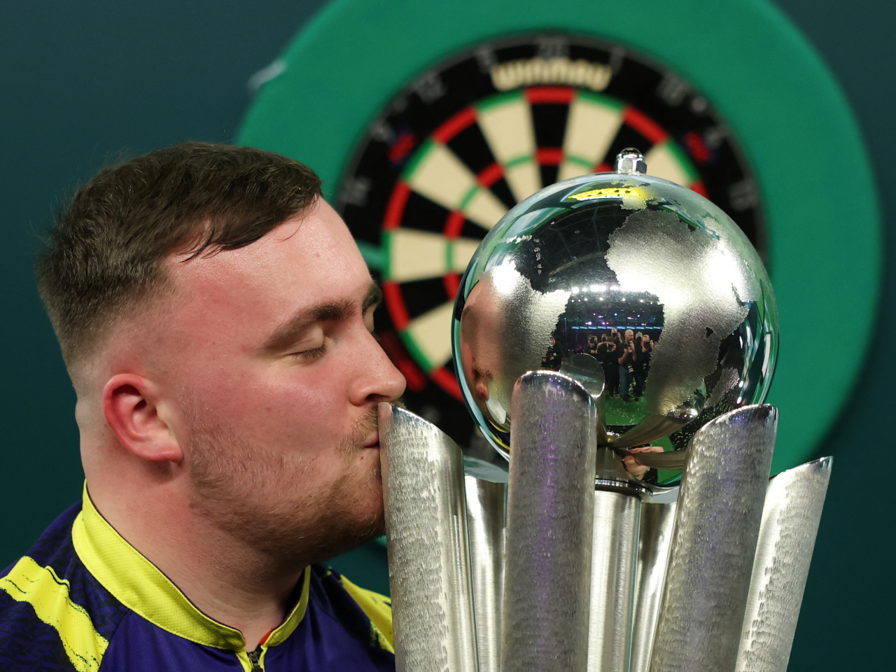 Luke Littler celebrates with the trophy after winning the World Darts Championship Action. Photo: Reuters