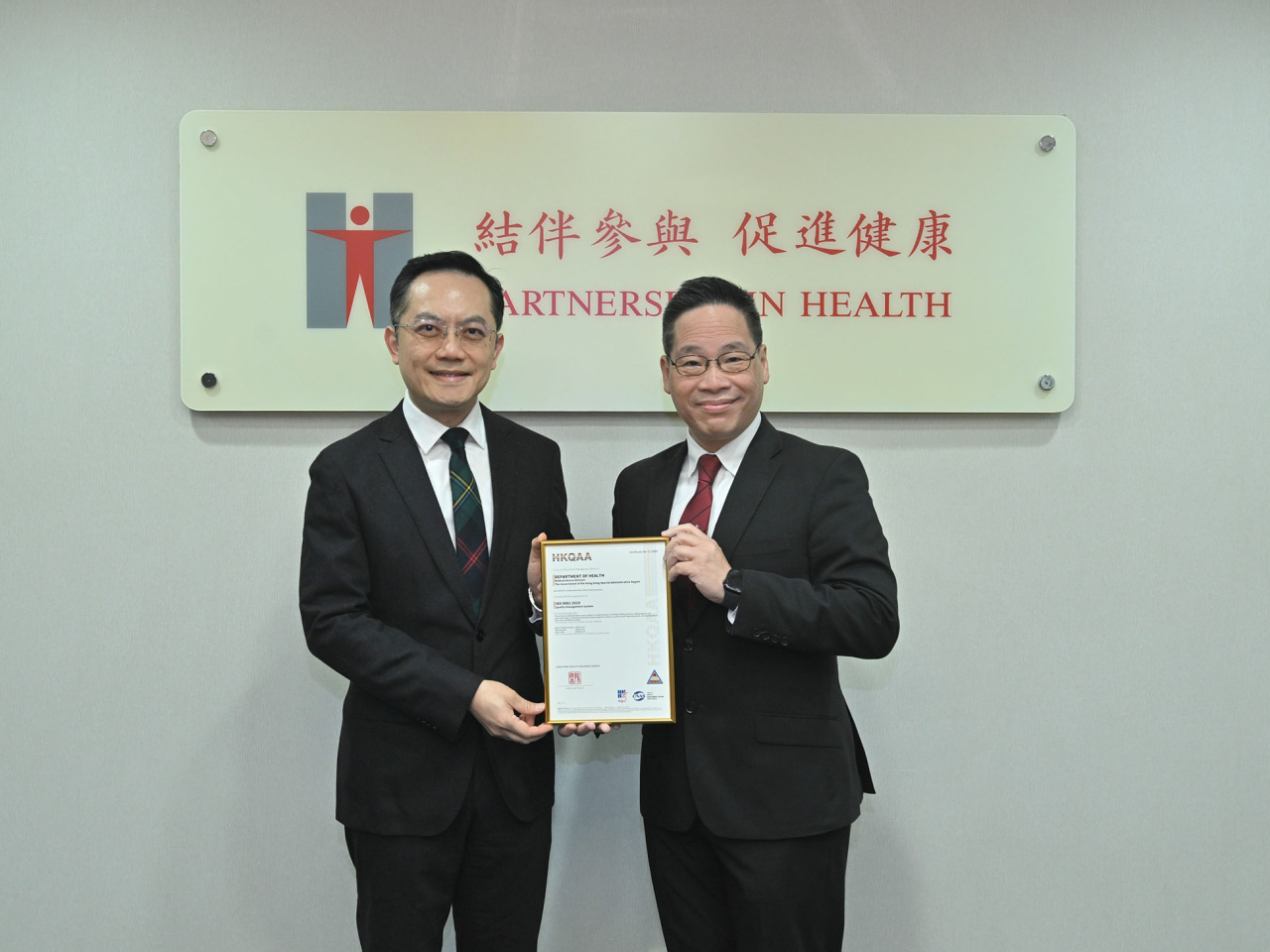 衞生署署長林文健在衞生署總部接受香港品質保證局總裁陳沛昌（右）頒發證書。（政府新聞處）