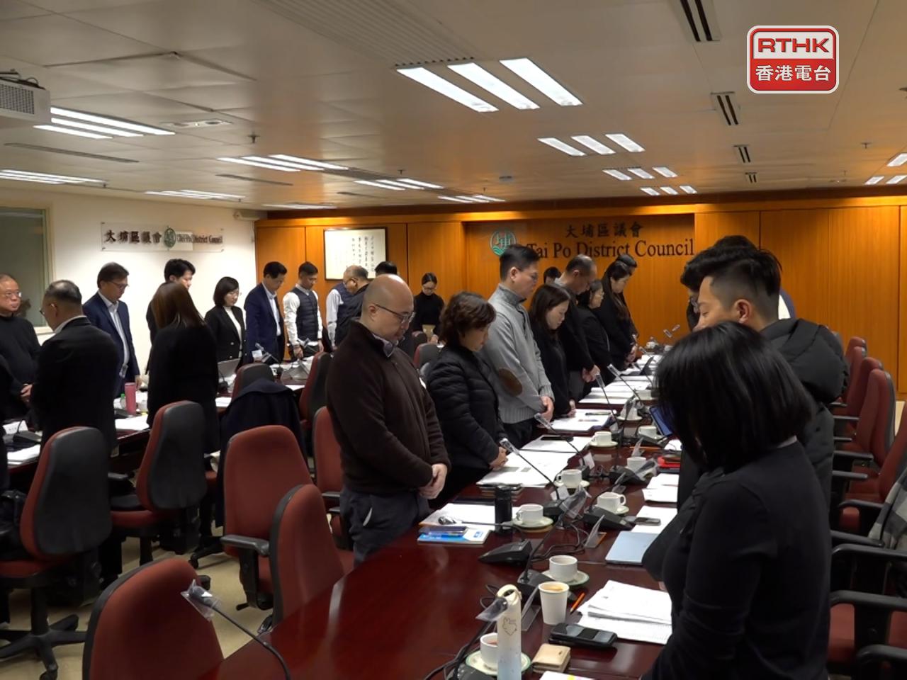 Officials and councillors observe a moment of silence at a district council meeting for those affected by the Tai Po fire. Photo: RTHK