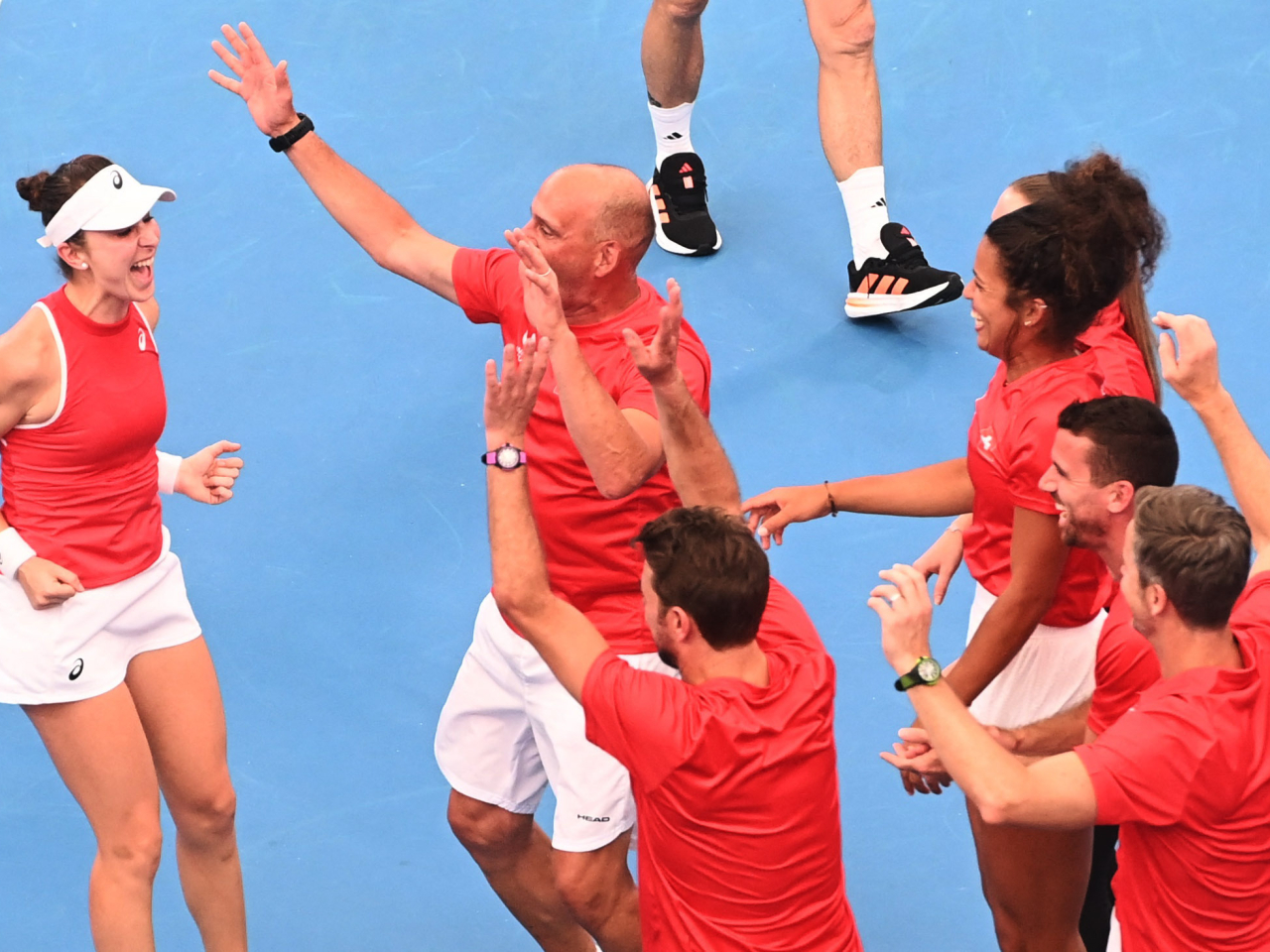 Belinda Bencic is celebrated by her Swiss teammates after her winning role in the mixed-doubles decider against Belgium in Sydney. Photo: Reuters