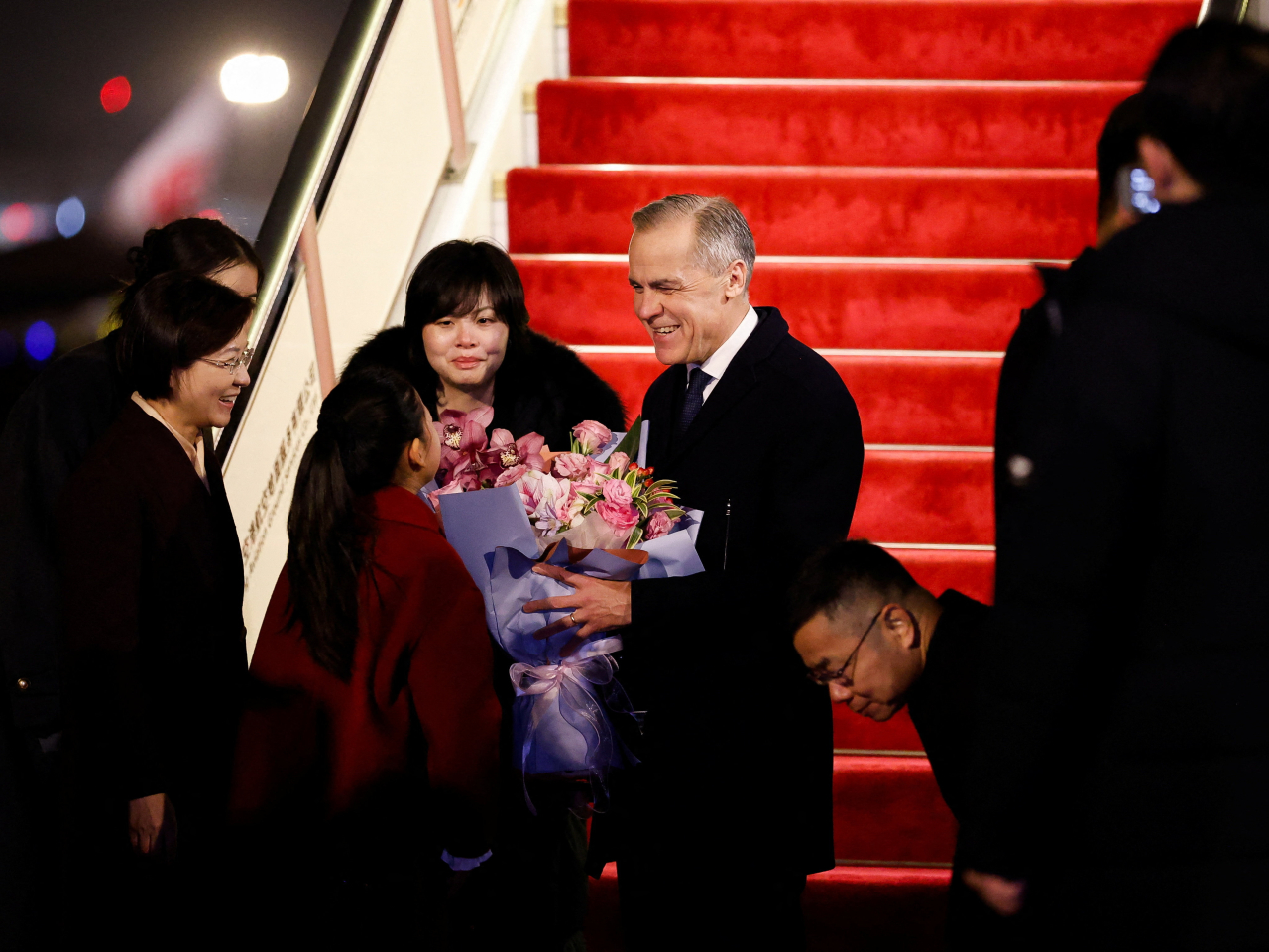 Canada's Prime Minister Mark Carney receives flowers upon his arrival at Beijing Capital International Airport. Photo: Reuters