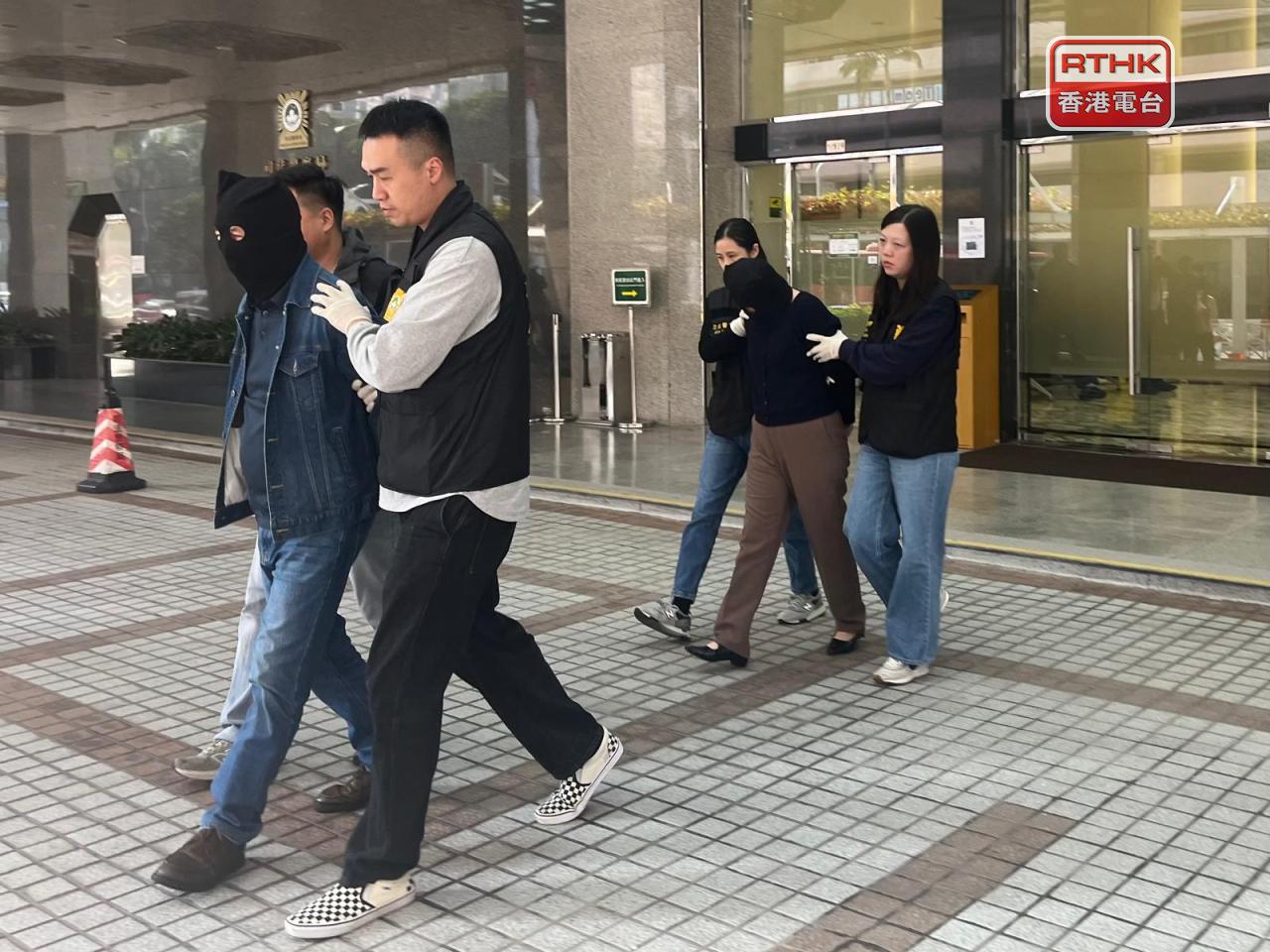 涉嫌開空殼公司詐騙事主投資2千多萬港元的港人夫婦，下午由司警押往檢察院。（鄭月明攝）