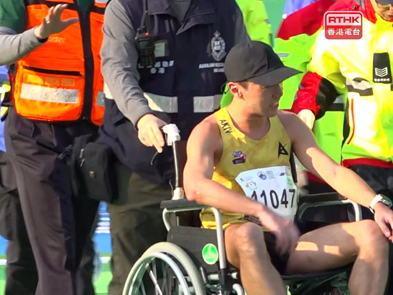 一名男跑手就在維園過終點後一度跌倒，需要坐輪椅離開。（陳裕行攝）