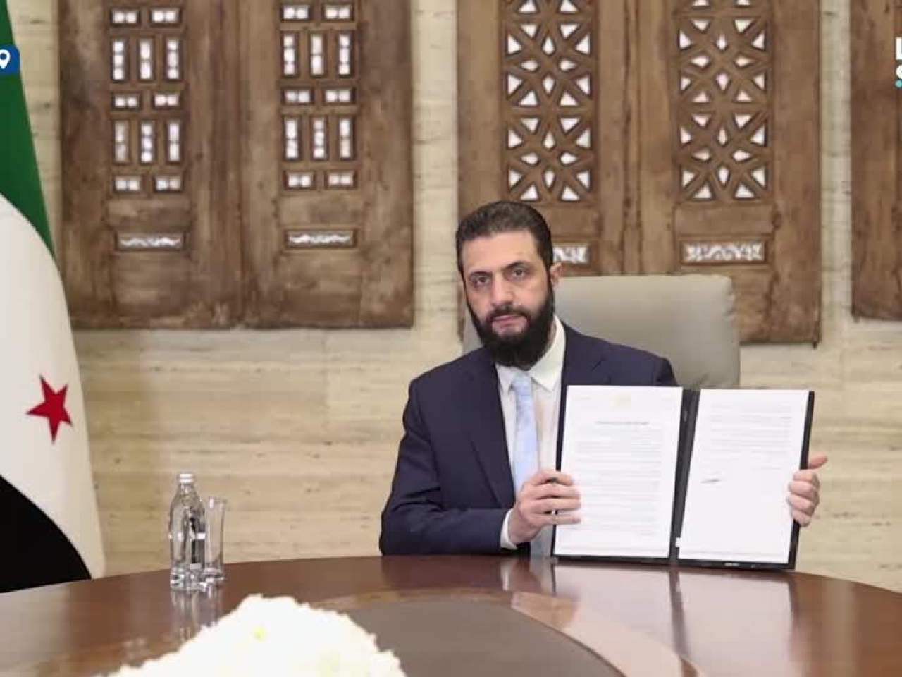 Syrian President Ahmed al-Sharaa shows reporters the 14-point agreement. Photo: Reuters