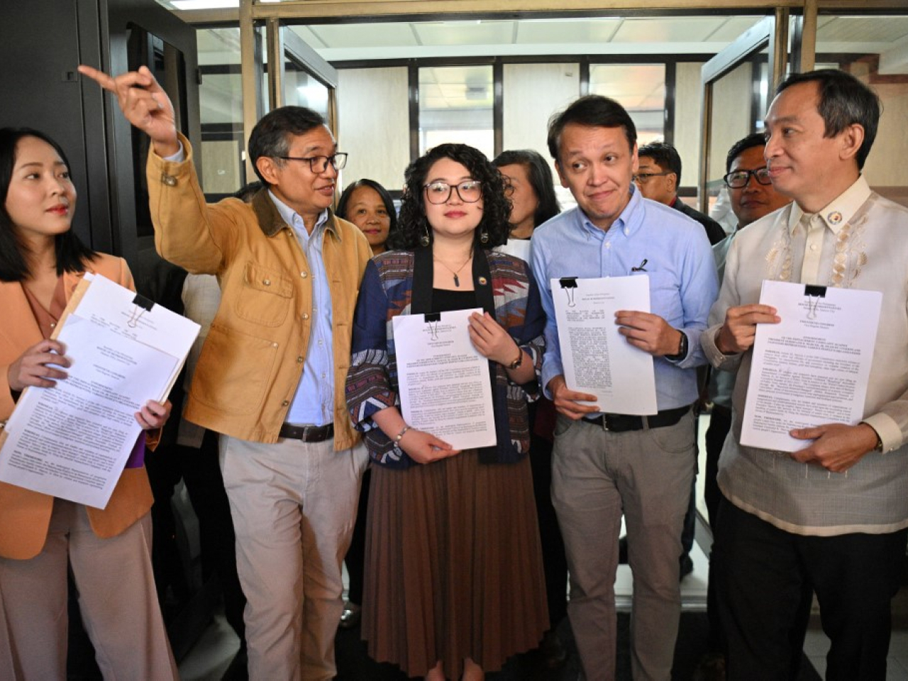 Lawmakers and activists hold copies of the impeachment complaint against President Ferdinand Marcos in the House of Representatives in Manila. Photo: AFP