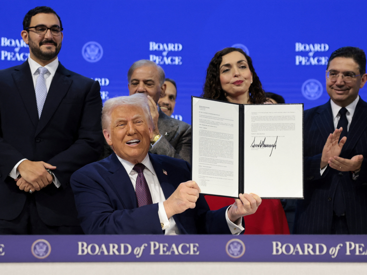 Leaders and senior officials from 19 countries gathered on stage with Donald Trump to put their names to the founding charter of the body. Photo: Reuters