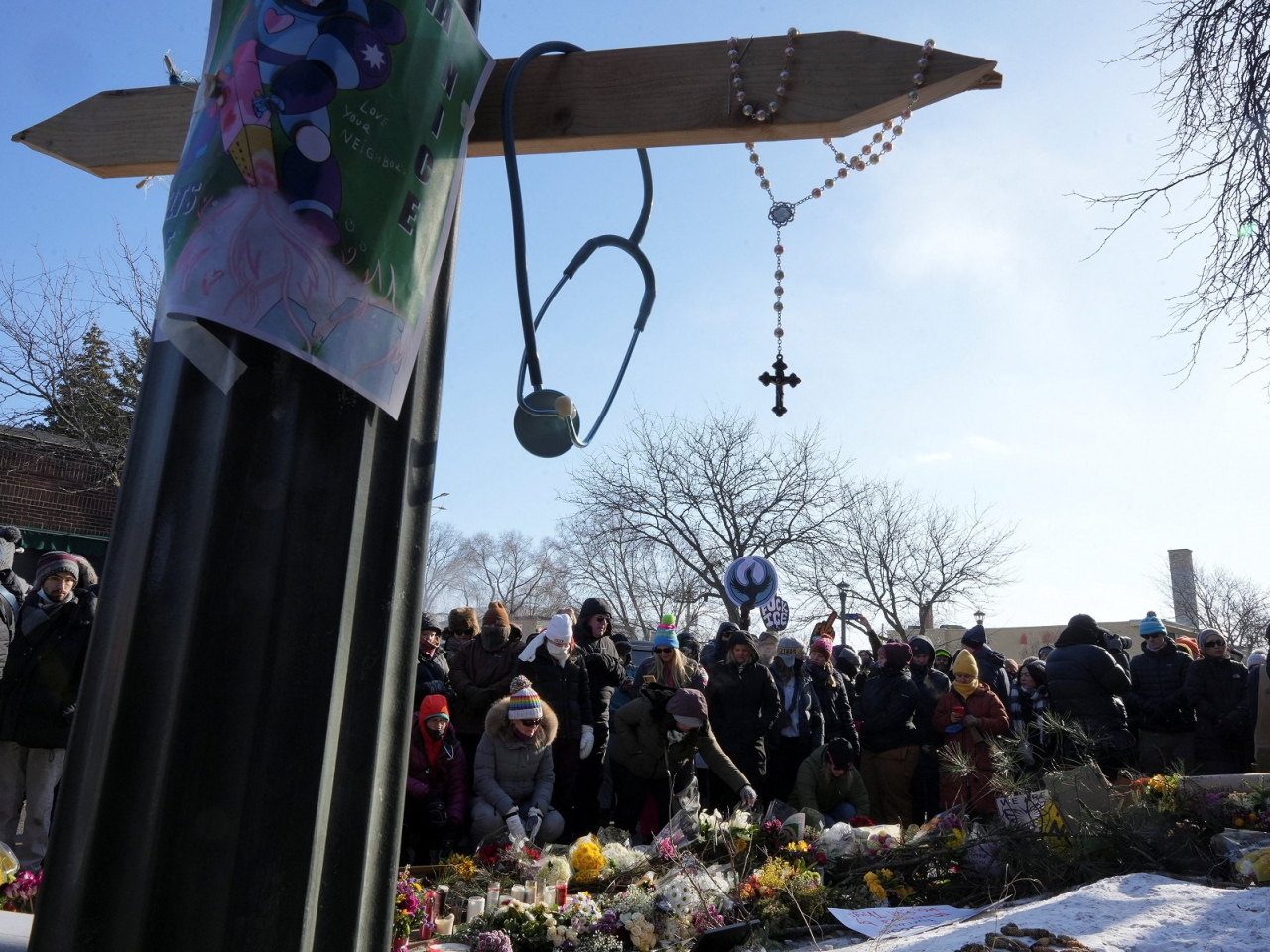 A cross and a stethoscope hang at a makeshift memorial as people gather at the site Alex Pretti was fatally shot by federal immigration agents. Photo: Reuters