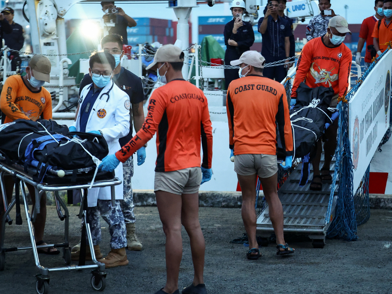 Philippine Coast Guard personnel carry body bags containing the remains of the crew members who died in the sinking of the cargo ship M/V Devon Bay. Photo: Reuters