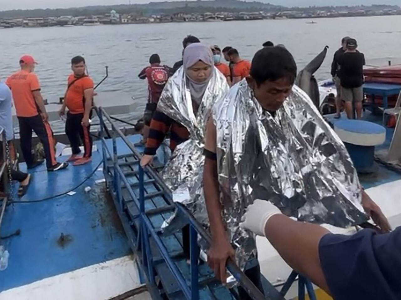 在伊莎貝拉港，有獲救的倖存者被送到岸上，部分人裹著保暖毯。（法新社）