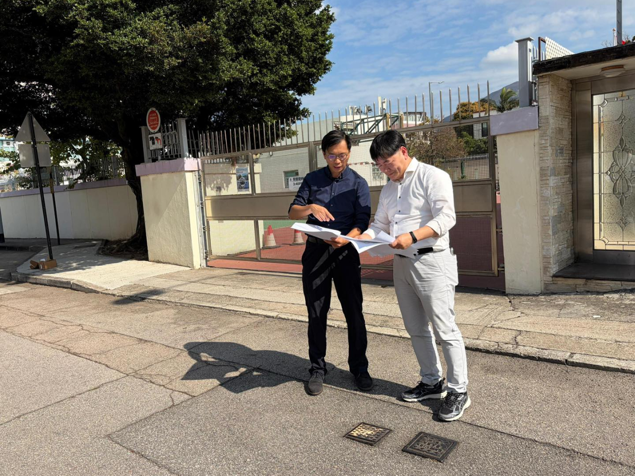 專家小組成員香港理工大學土地測量及地理資訊學系副系主任賴緯樂 (左) 及國際管綫專業學會會長黃敬 (右) 今日在錦綉花園進行實地勘察 。（水務署社交平台)