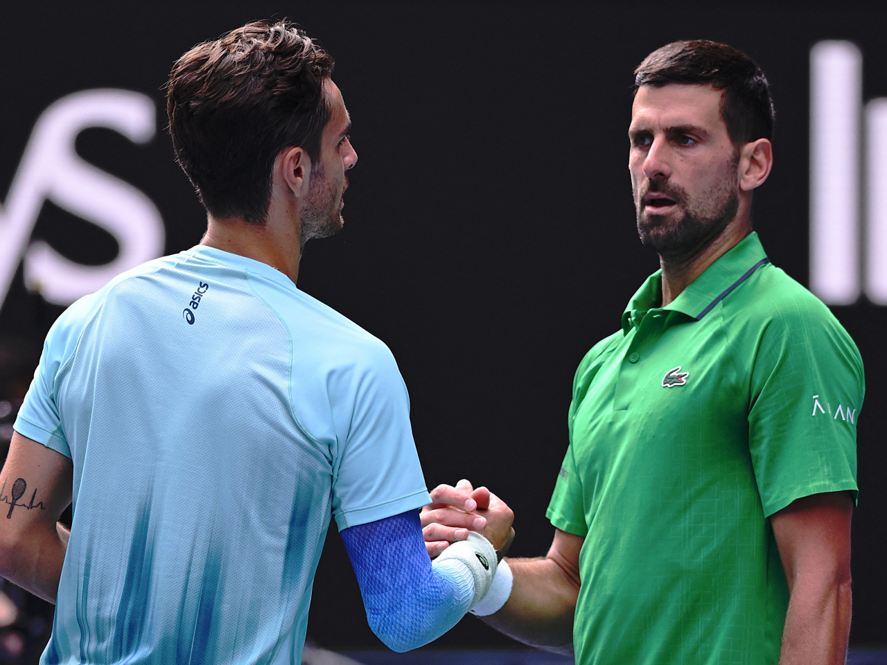 Italy's Lorenzo Musetti shakes hands with Serbia's Novak Djokovic after retiring from his quarter final match. Photo: Reuters
