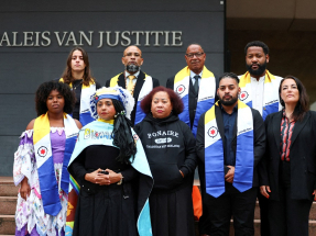 Environmental activists pose in front of the court before the start of the case brought by Greenpeace and residents of the Dutch-Caribbean island of Bonaire. Photo: Reuters