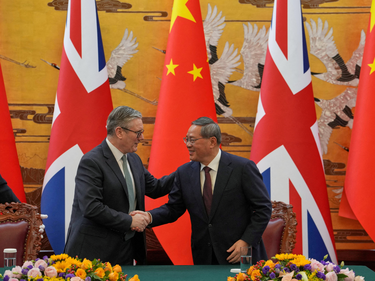 李強同施紀賢會面時握手。（路透社）