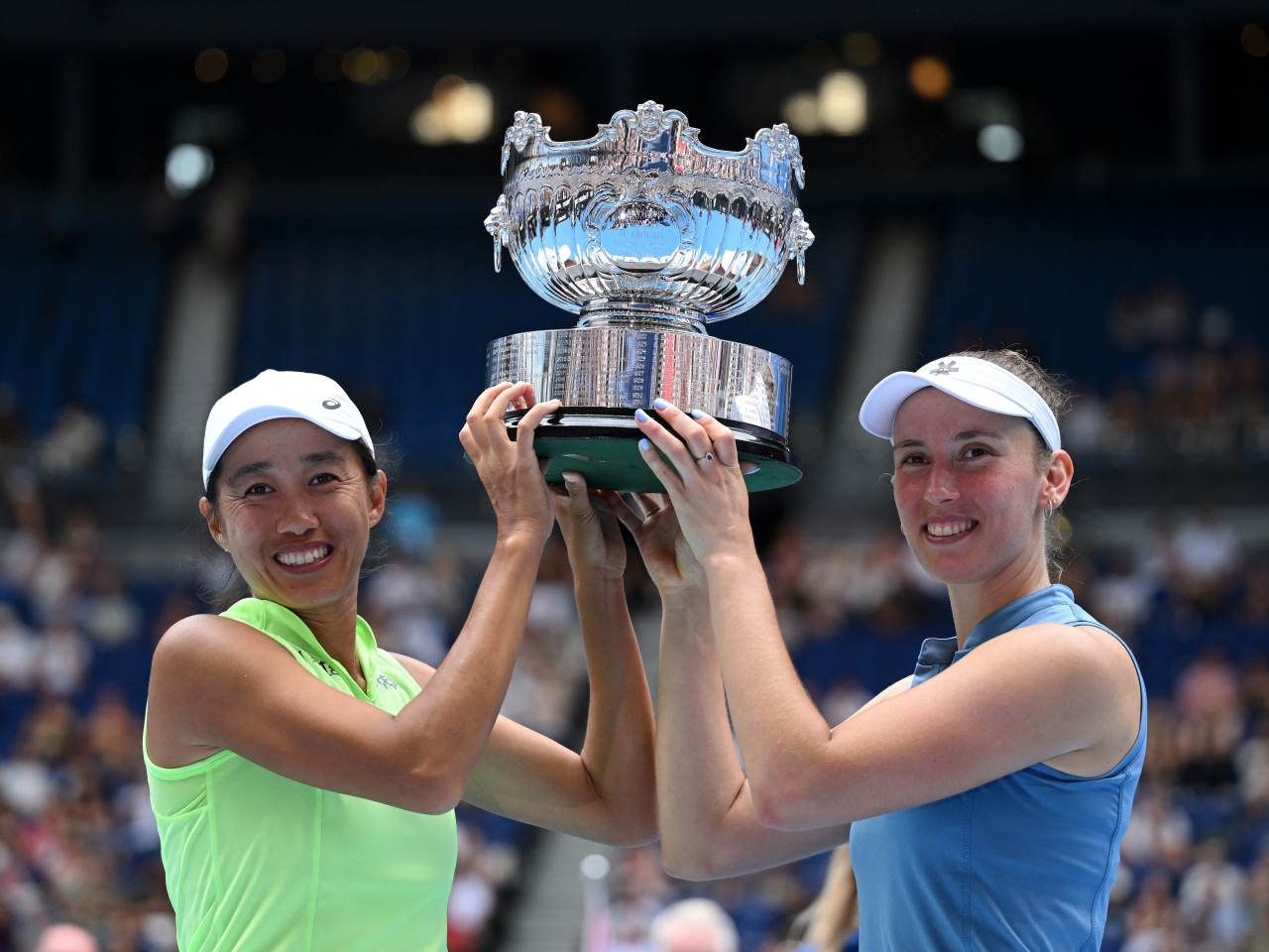 Zhang Shuai and Elise Mertens beam as they hold up their Australian Open women's doubles trophy in Melbourne. Photo: Reuters