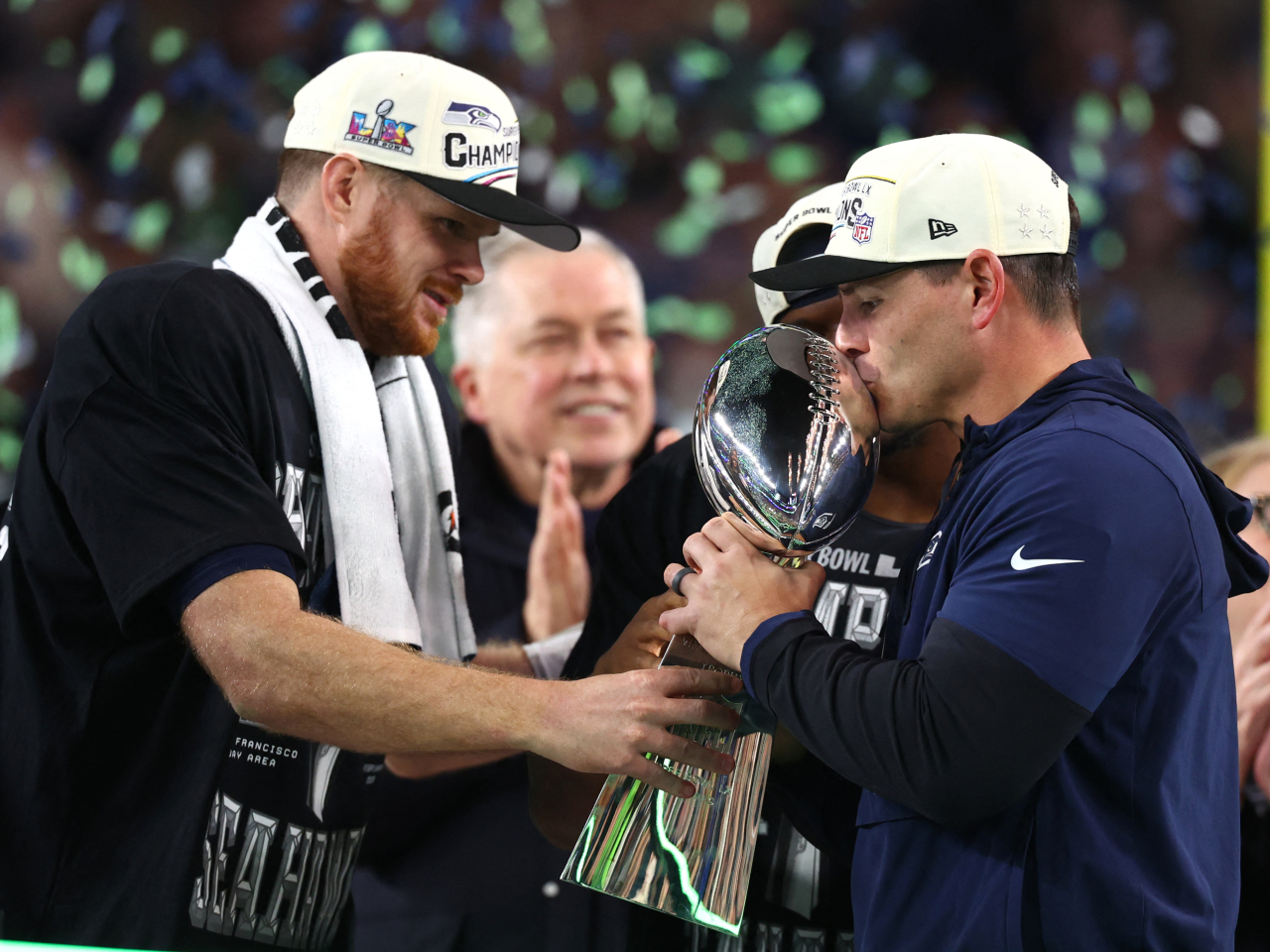 Seattle Seahawks head coach Mike MacDonald, right, and quarterback Sam Darnold celebrate with the Vince Lombardi trophy on the podium. Photo: Reuters