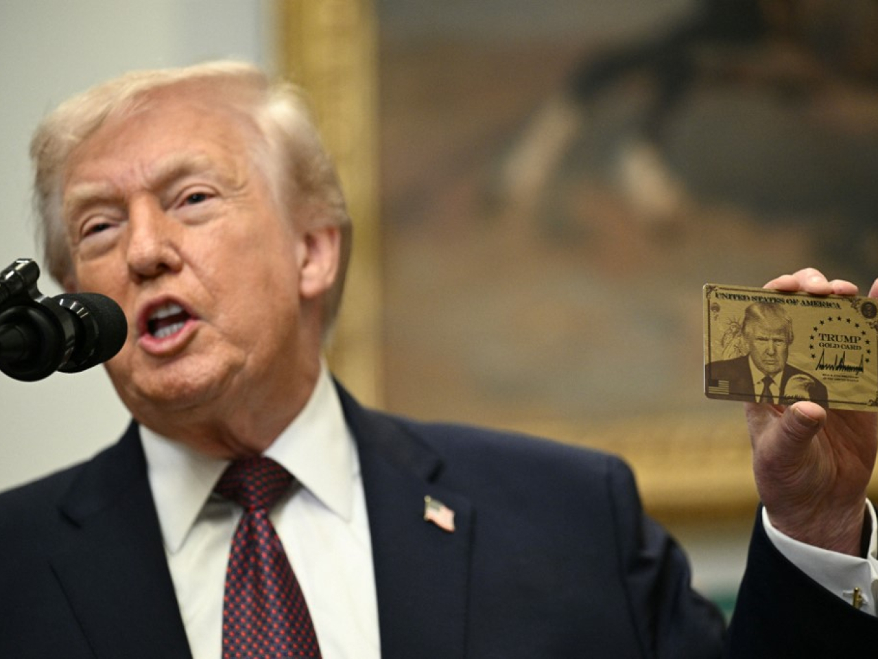 Donald Trump holds up a US$1 million 'Trump Gold Card'  in the White House as part of a residency programme to attract rich immigrants. File photo: AFP