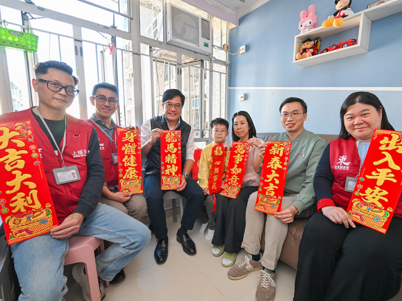 黃偉綸(左三)探訪耀東邨的年青家庭。(政府新聞處)