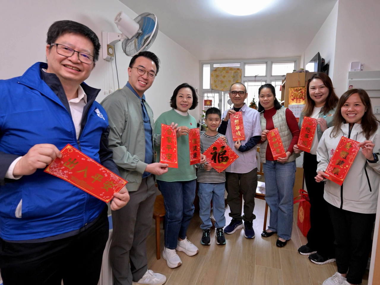 麥美娟（左三）等人探訪居於長安邨的中產家庭。（政府新聞處）