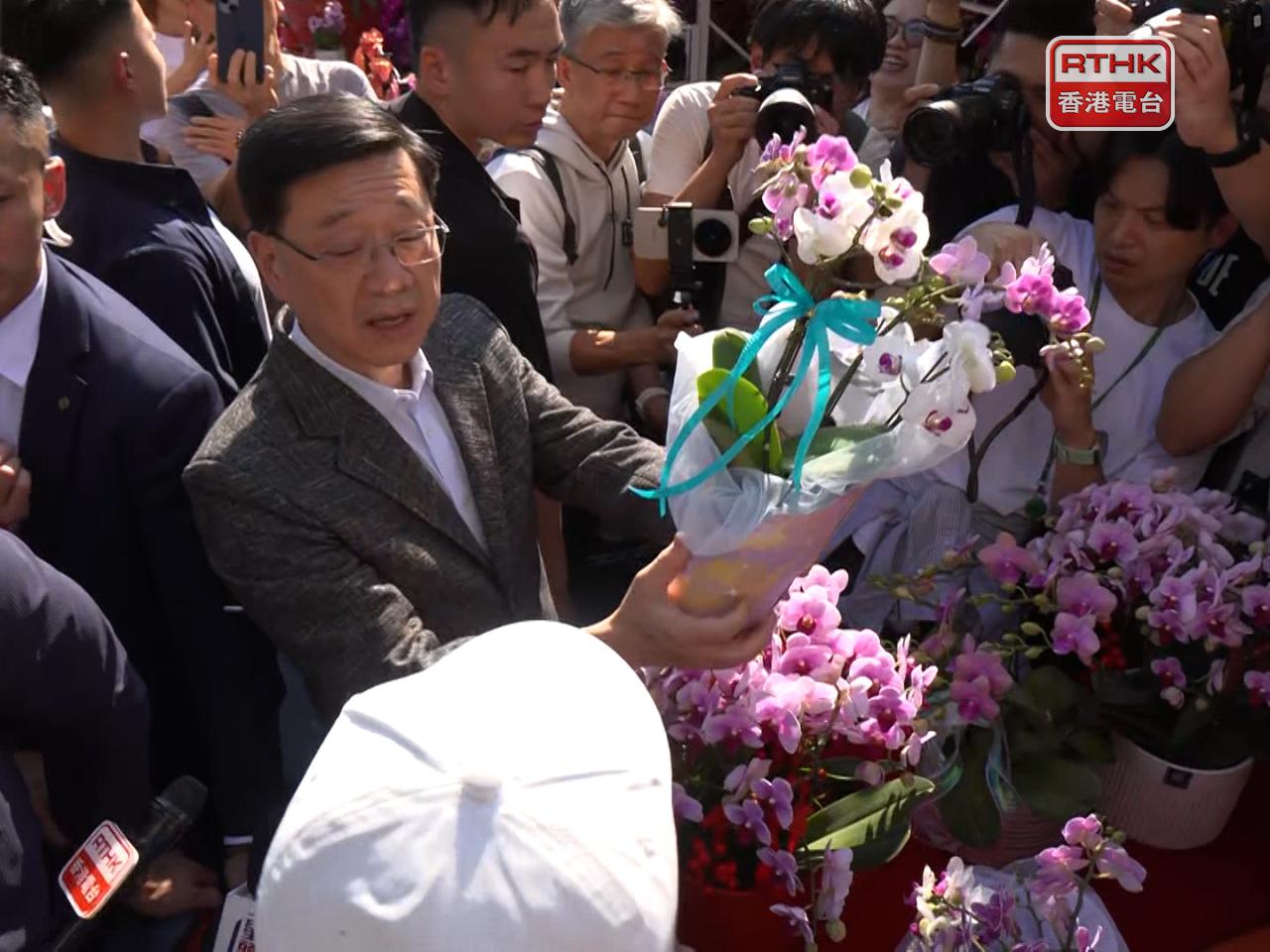 李家超亦到一個攤檔購買蘭花和一束花。（鍾家銘攝）