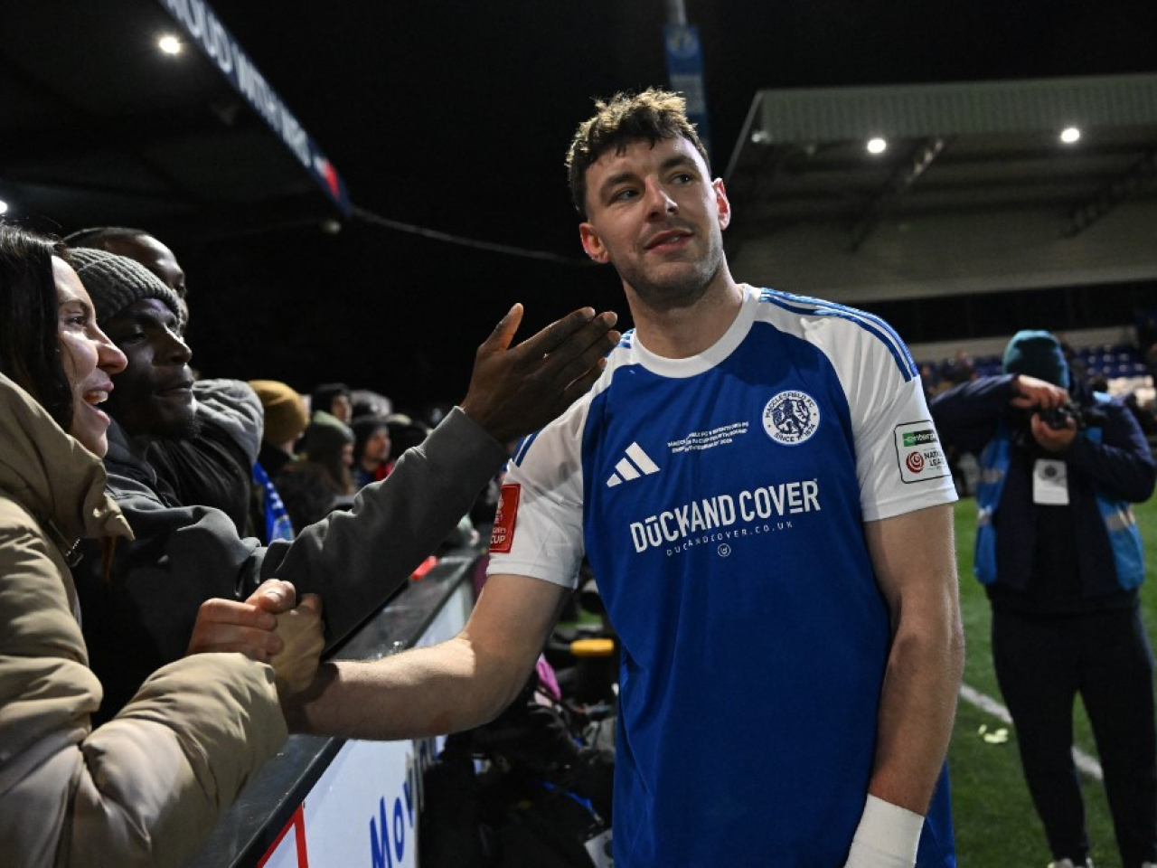 PE teacher Sam Heathcote is consoled by fans after his own goal knocked Macclesfield out of the FA Cup. Photo: AFP