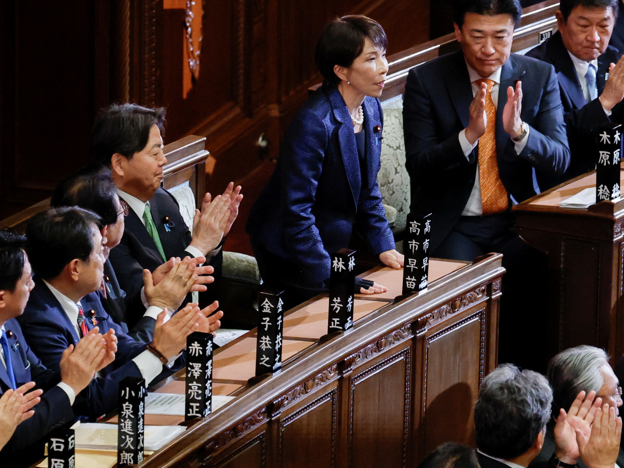 Sanae Takaichi bows in acknowledging applause by lawmakers in the lower house following her reelection as prime minister. Photo: Reuters