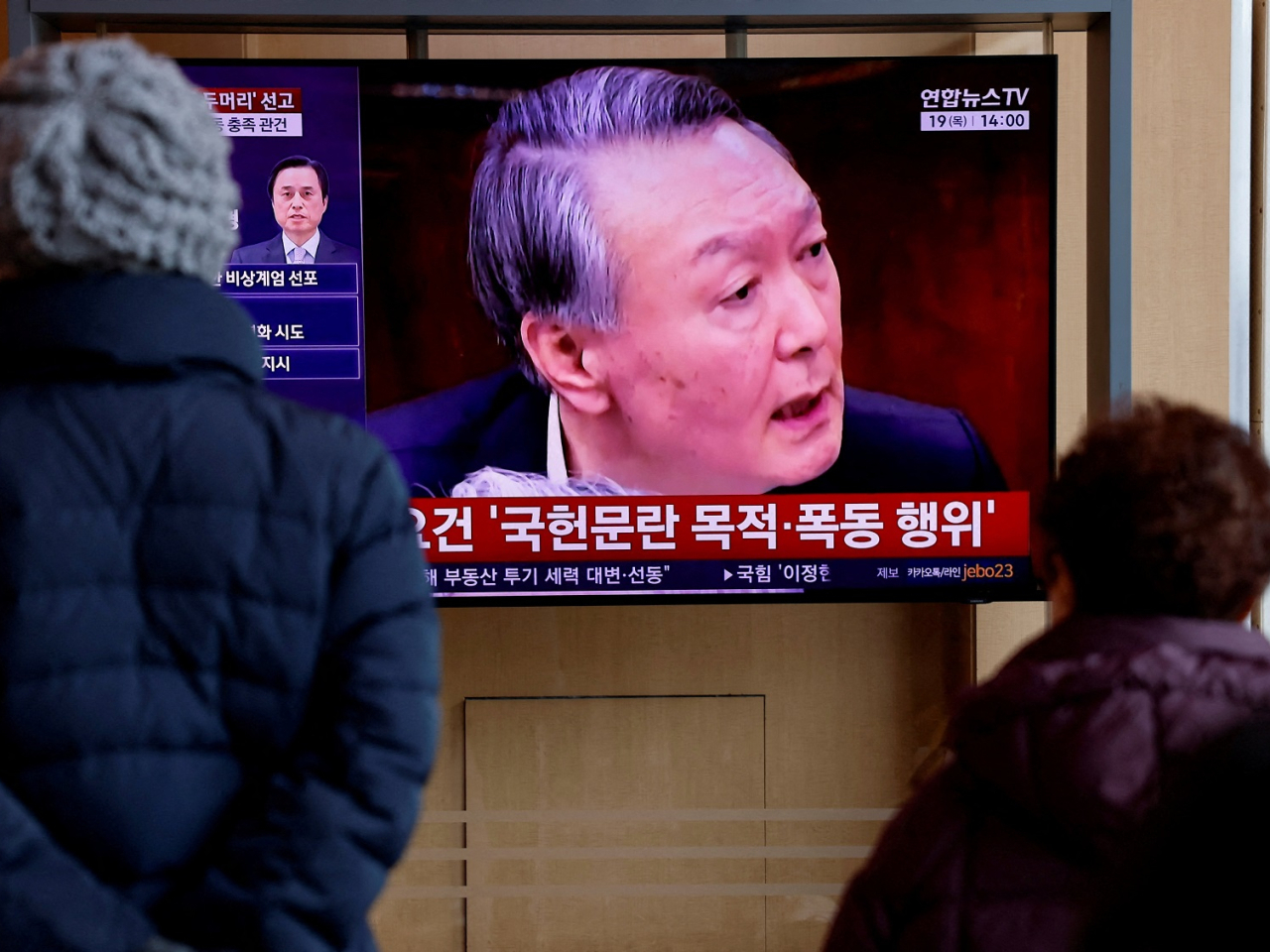 South Koreans watch a news report on the sentencing trial of former president Yoon Suk Yeol's insurrection case. Photo: Reuters
