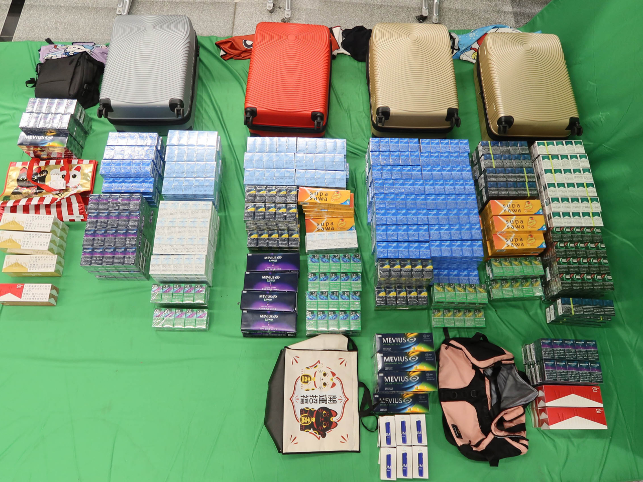 海關於兩名旅客的個人行李內檢獲的未完稅香煙及另類吸煙產品。（政府新聞處）