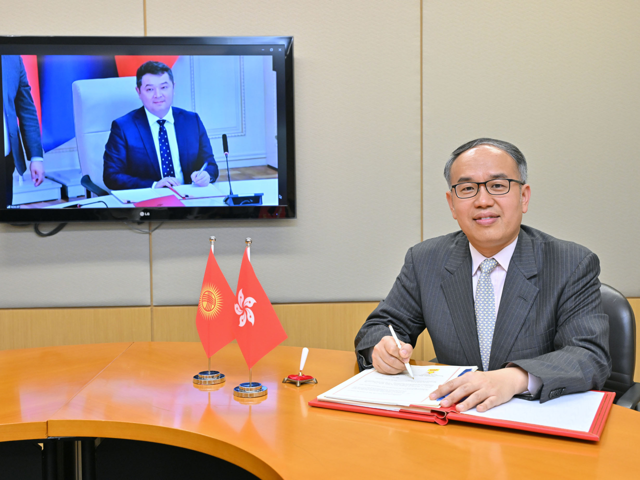 許正宇（右）與吉爾吉斯共和國經濟和商務部部長Bakyt Tolomushevich Sydykov（左）分別代表香港特別行政區政府與吉爾吉斯共和國政府簽署全面性避免雙重課稅協定。（政府新聞處）