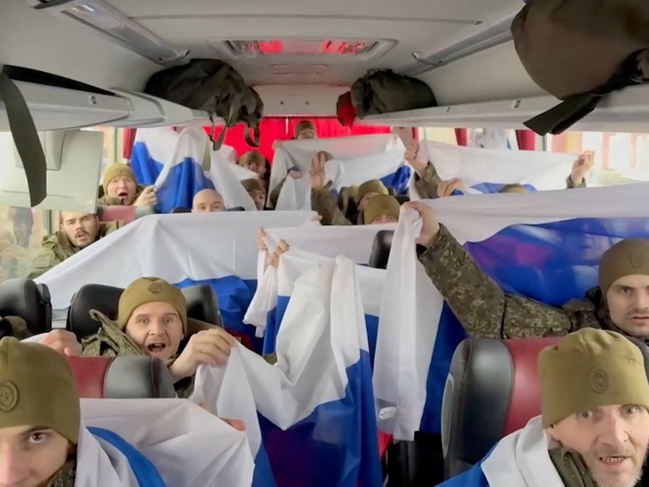 The Russian defence ministry published footage showing its soldiers boarding a bus and cheering while draped in Russian flags. Photo: Reuters